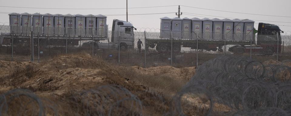 Des camions d'aide entre Kerem Shalom et l'Égypte. [Keystone/AP Photo - Leo Correa]