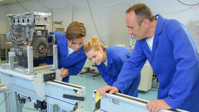 Des apprentis découvrent des machines sous la supervision de leur patron. [Depositphotos - Photography33]