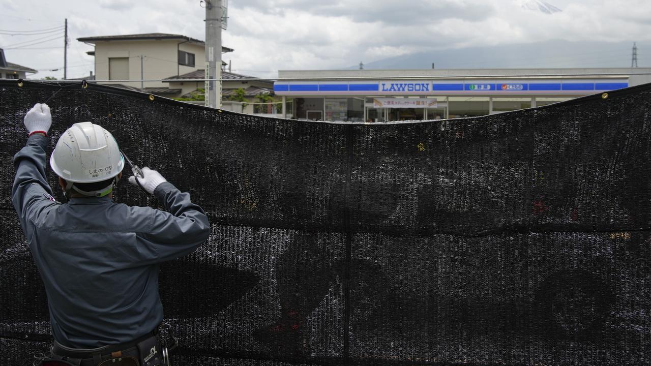 La bâche anti-touristes installée au mont Fuji a été retirée à titre d'essai. [Keystone - EPA / FRANCK ROBICHON]