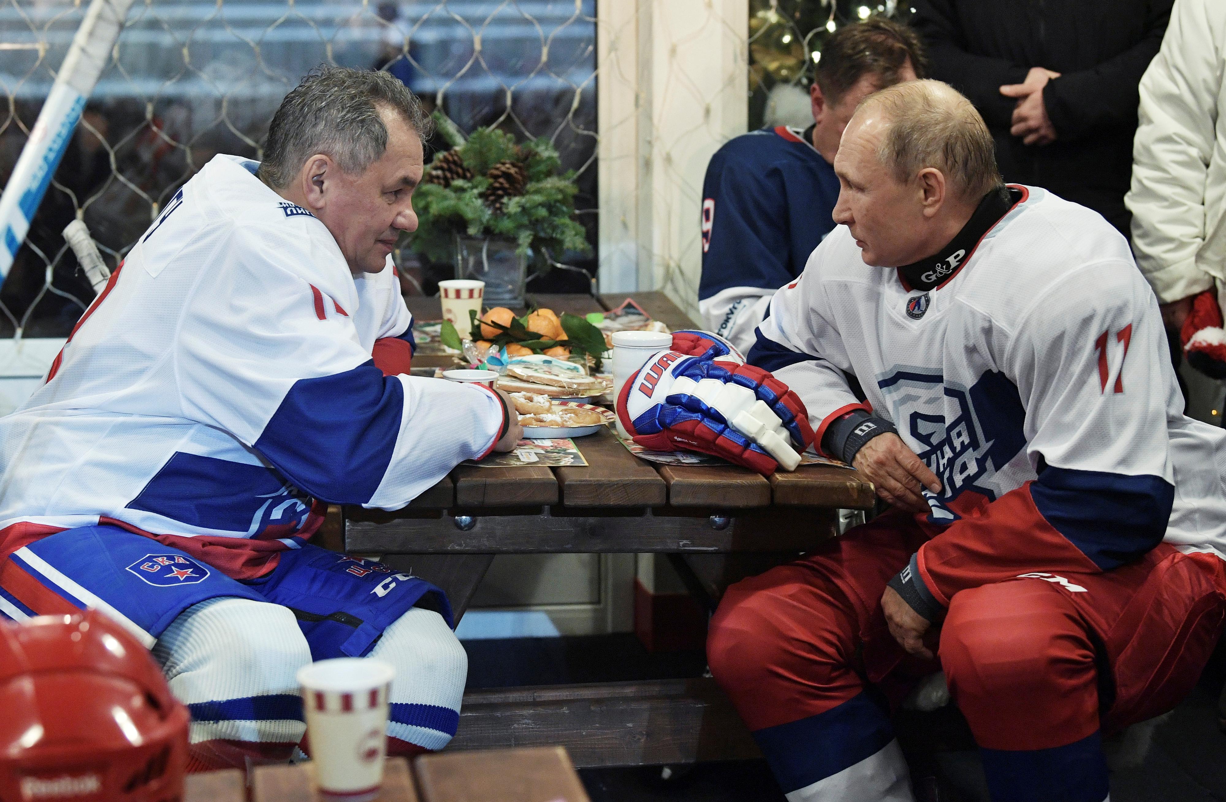Le président russe Vladimir Poutine s'entretient avec Sergueï Choïgou après un match d'exhibition de la Ligue de hockey de nuit, sur la place Rouge, à Moscou, le 29 décembre 2018. [REUTERS via Spoutnik - Alexei Nikolsky]