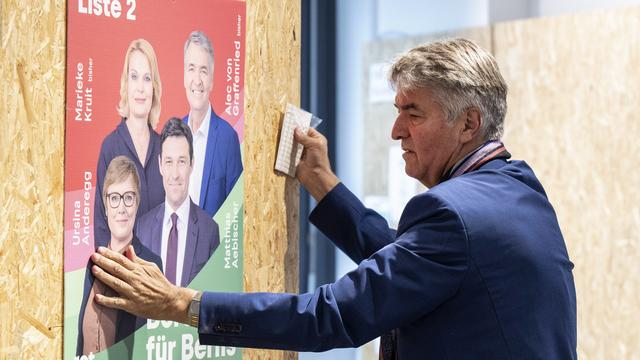 Le maire de Berne Alec von Graffenried pose une affiche électorale. [Keystone - Peter Schneider]