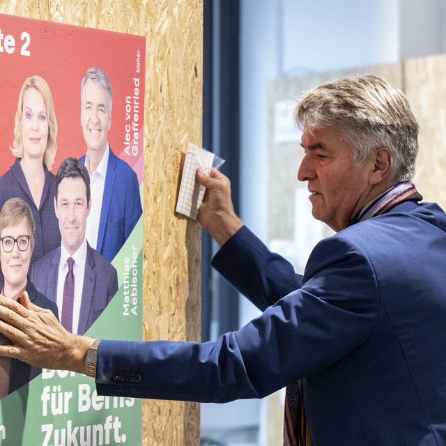 Le maire de Berne Alec von Graffenried pose une affiche électorale. [Keystone - Peter Schneider]