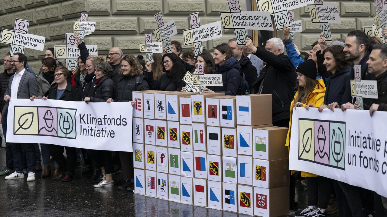 Le Parti socialiste et les Vert-e-s ont déposé jeudi 130’000 signatures en faveur de l'initiative pour un fonds climat à la Chancellerie fédérale. [Keystone - Peter Schneider]