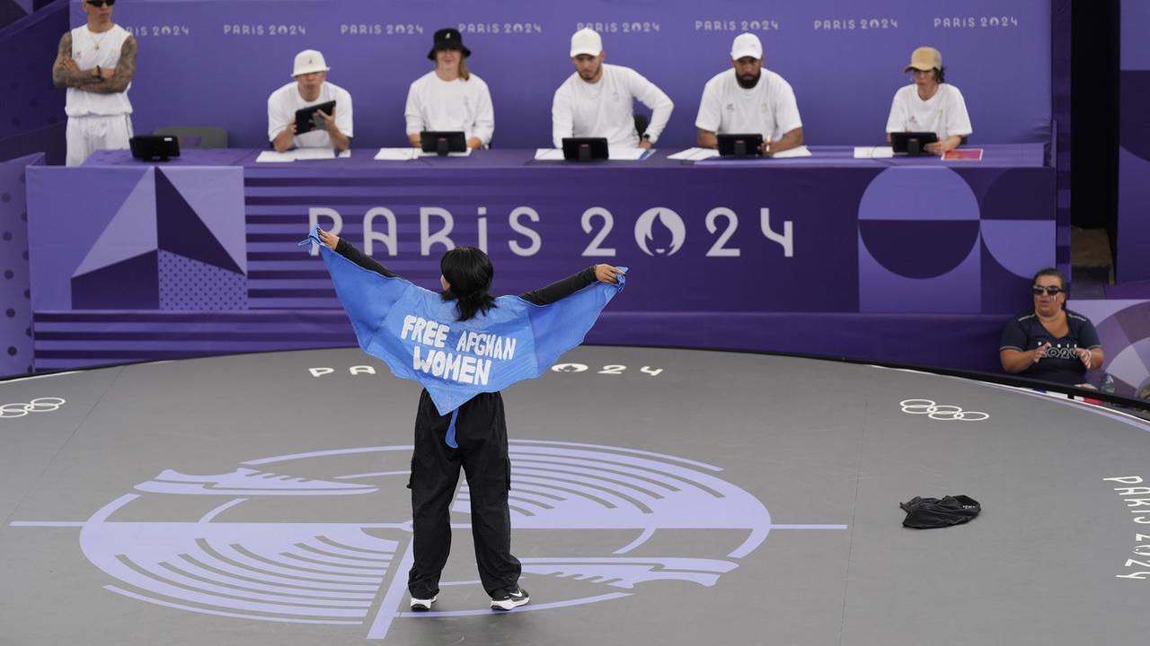 La breakeuse afghane Manizha Talash porte une cape avec l'inscription "Free afghan women" durant les Jeux olympiques de Paris 2024. [AP Photo/Keystone - Abbie Parr]