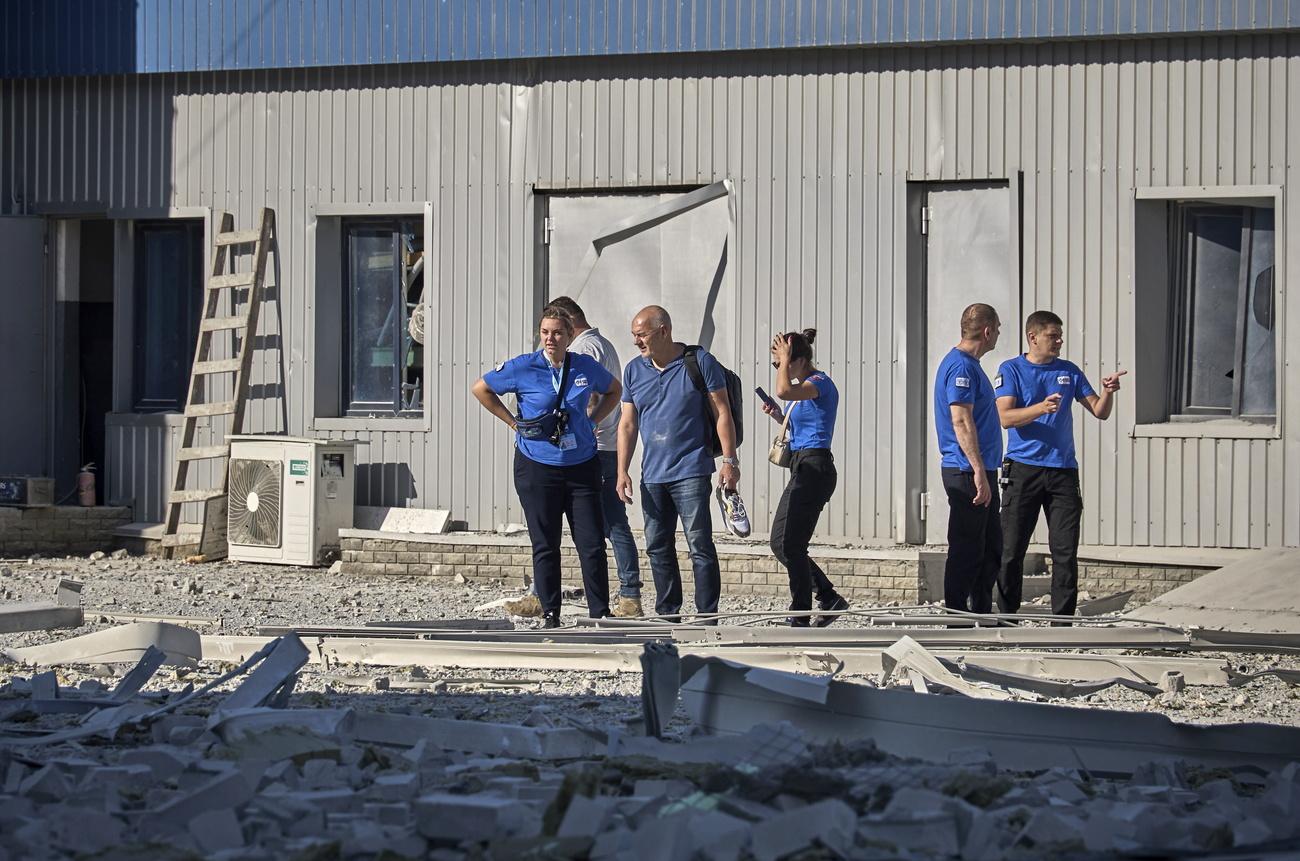 Les employés de FSD constatent les dégâts après la frappe de missile russe. [Keystone - Sergey Kozlov - EPA]