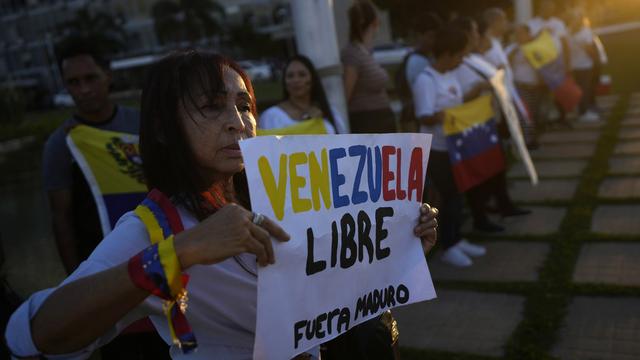 Des manifestants brandissent des affiches mettant en cause la réélection de Nicolas Maduro au Venezuela. [KEYSTONE - ERALDO PERES]