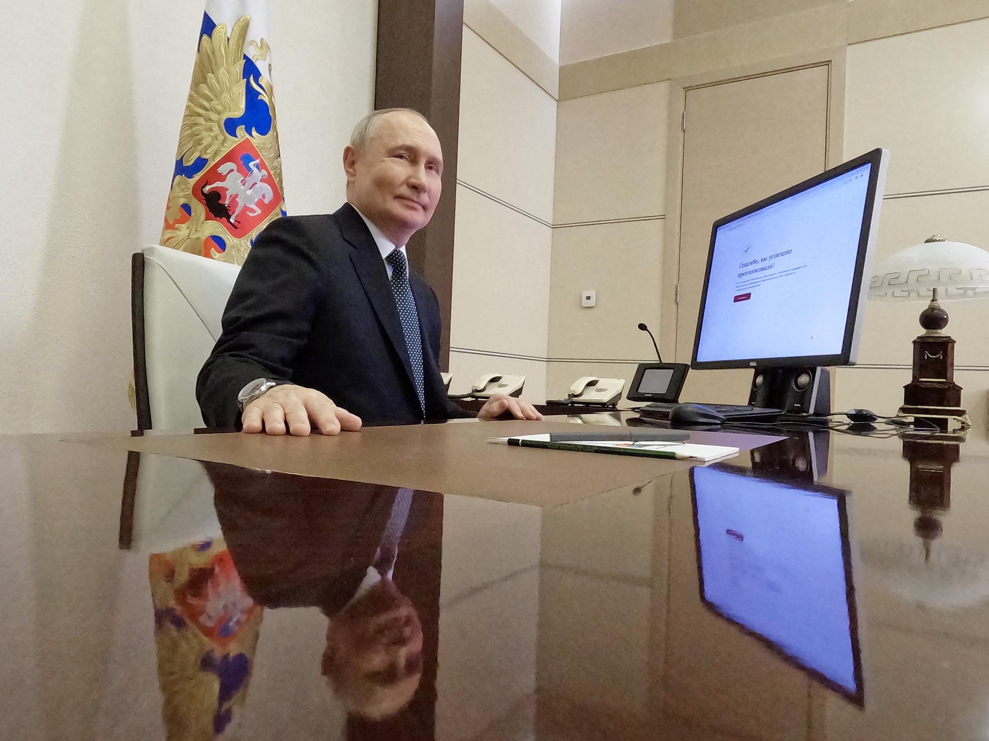 Le président russe Vladimir Poutine pose devant son ordinateur après avoir voté en ligne. [AFP - MIKHAIL METZEL]