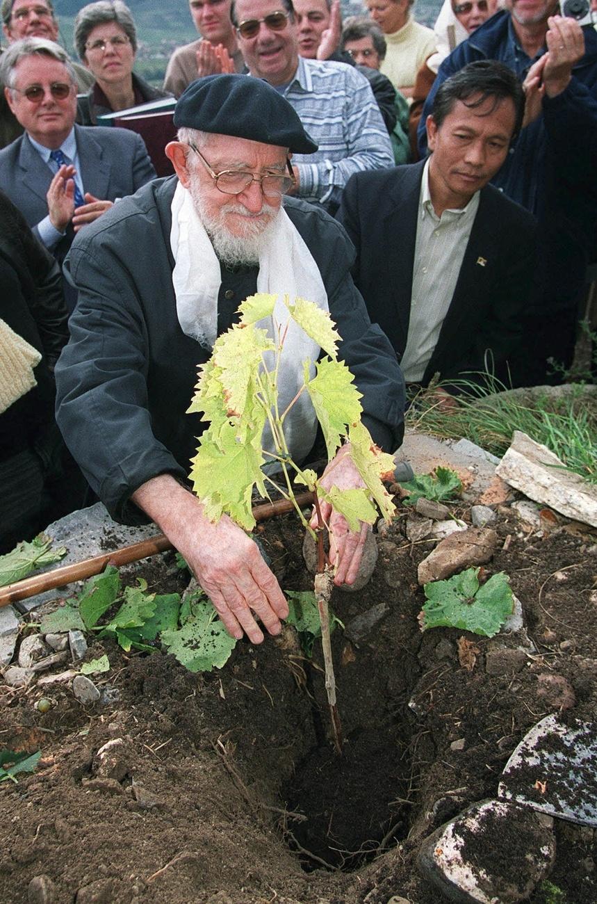 L'abbe Pierre procède à la mise en terre d'un cep sur la Vigne à Farinet, le 4 octobre 1999, à Saillon (VS). [KEYSTONE - FABRICE COFFRINI]