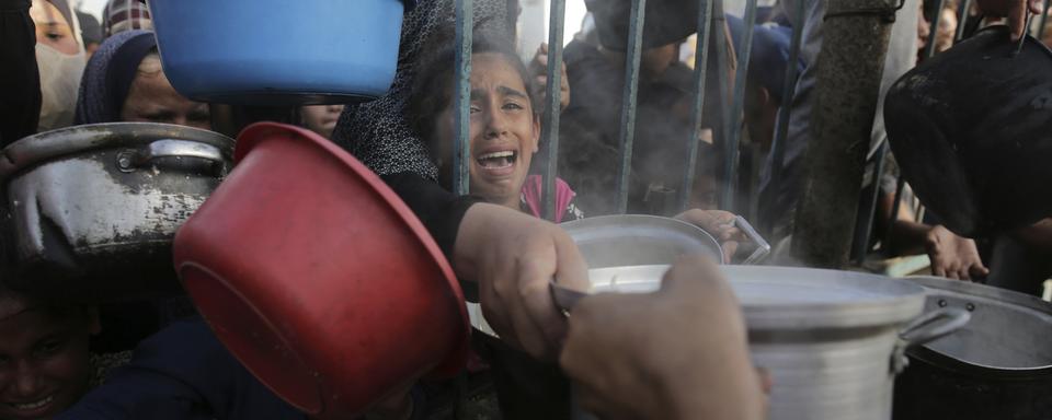 Une fille palestinienne pendant une récolte de nourriture lors de la fête de l'Aïd à Gaza. [Keystone/AP Photo - Jehad Alshrafi]