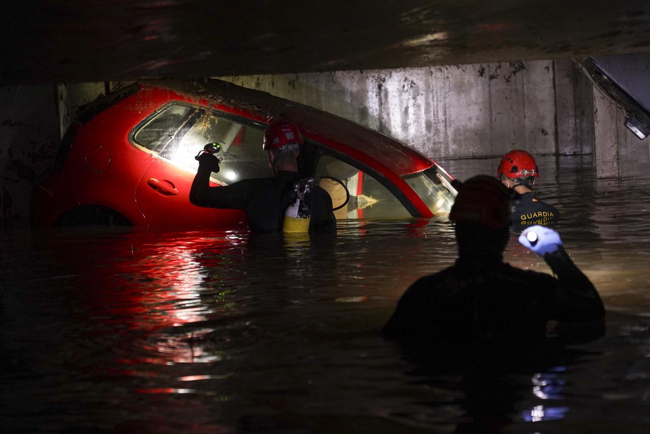 Des secouristes inspectent des voitures dans un parking couvert inondé pour vérifier s'il n'y a pas de corps à l'intérieur après les inondations à Paiporta, près de Valence, en Espagne, le 4 novembre 2024. [KEYSTONE - ALBERTO SAIZ]