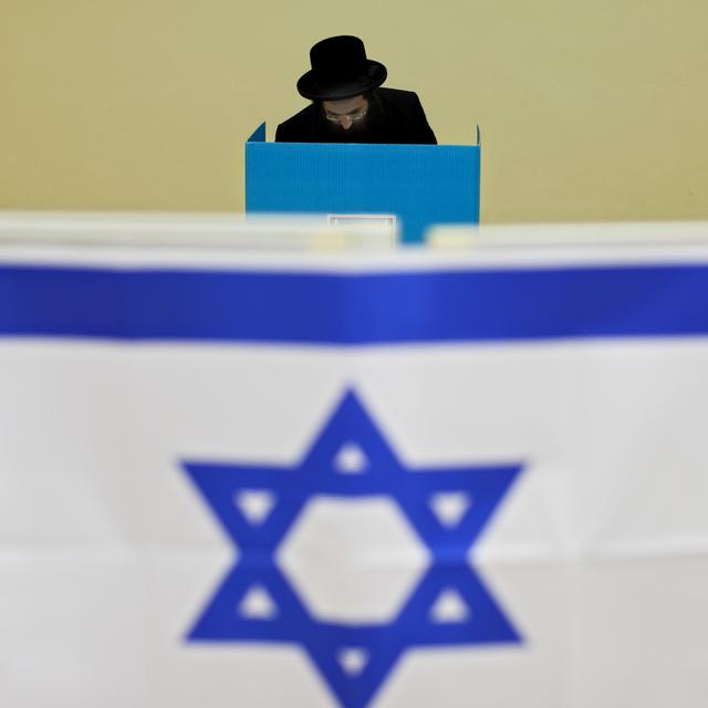 Un homme israélien de confession juive ultra-orthodoxe vote dans une ville vers Tel Aviv. [Keystone/AP Photo - Oded Balilty]