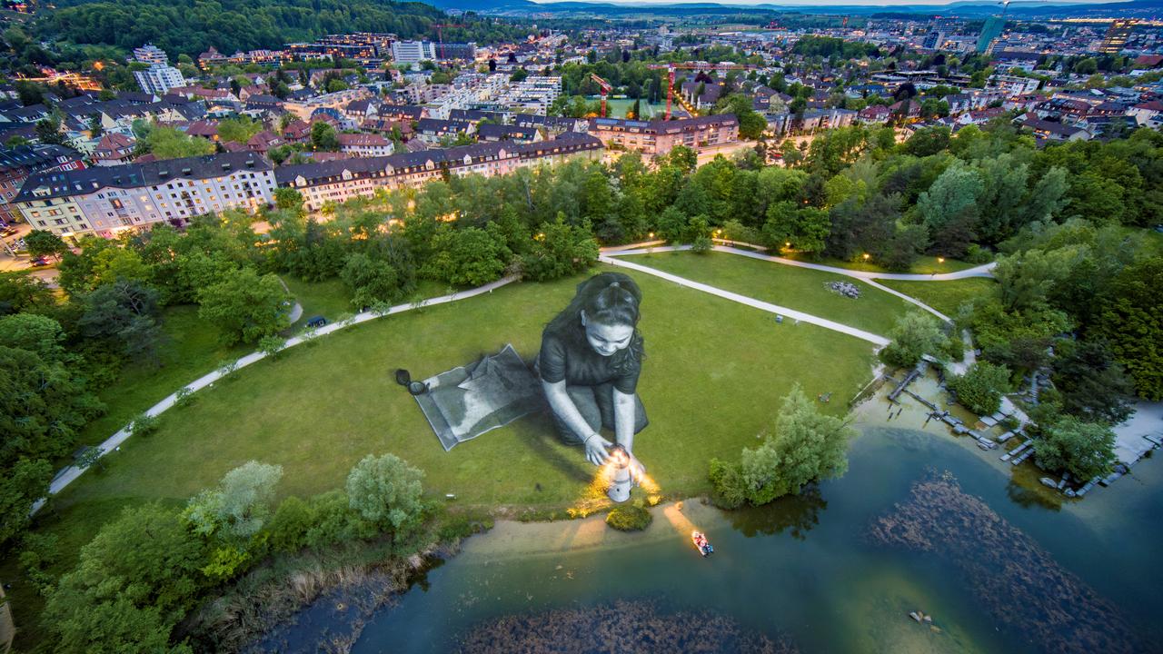 Photographie aérienne qui montre l'œuvre d'art éphémère géante de 4500 mètres carrés intitulée "Bright Dreams" peinte par Saype dans l'Irchelpark, à Zurich. [afp - Guillaume Legros]