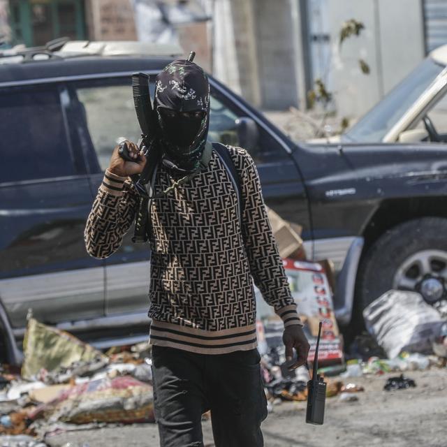 Un membre armé du gang G9 patrouille à un barrage routier dans le quartier de Delmas 6 à Port-au-Prince, en Haïti, le 11 mars 2024. [Keystone - AP Photo/Odelyn Joseph]