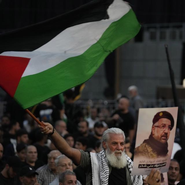 Un soutien du Hezbollah avec un drapeau palestinien. [Keystone/AP Photo - Hussein Malla]