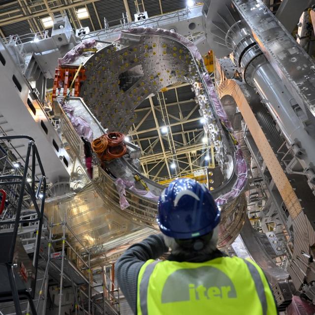 Un homme prend une photo d'un module en cours d'assemblage dans le cadre du projet international de fusion nucléaire Iter à Saint-Paul-les-Durance, dans le sud de la France, le 5 janvier 2023. [AFP - Nicolas Tucat]