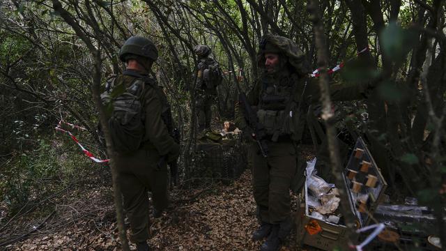 Israeli soldiers display what they say are Hezbollah ammunition and explosives found during their ground operation in southern Lebanon, near the border with Israel, Sunday, Oct. 13, 2024. [AP Photo/Keystone - Sam McNeil]