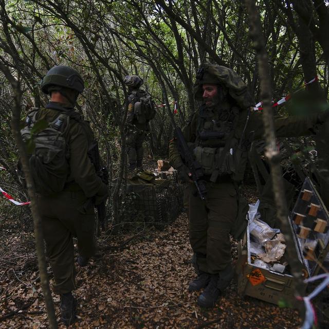 Israeli soldiers display what they say are Hezbollah ammunition and explosives found during their ground operation in southern Lebanon, near the border with Israel, Sunday, Oct. 13, 2024. [AP Photo/Keystone - Sam McNeil]