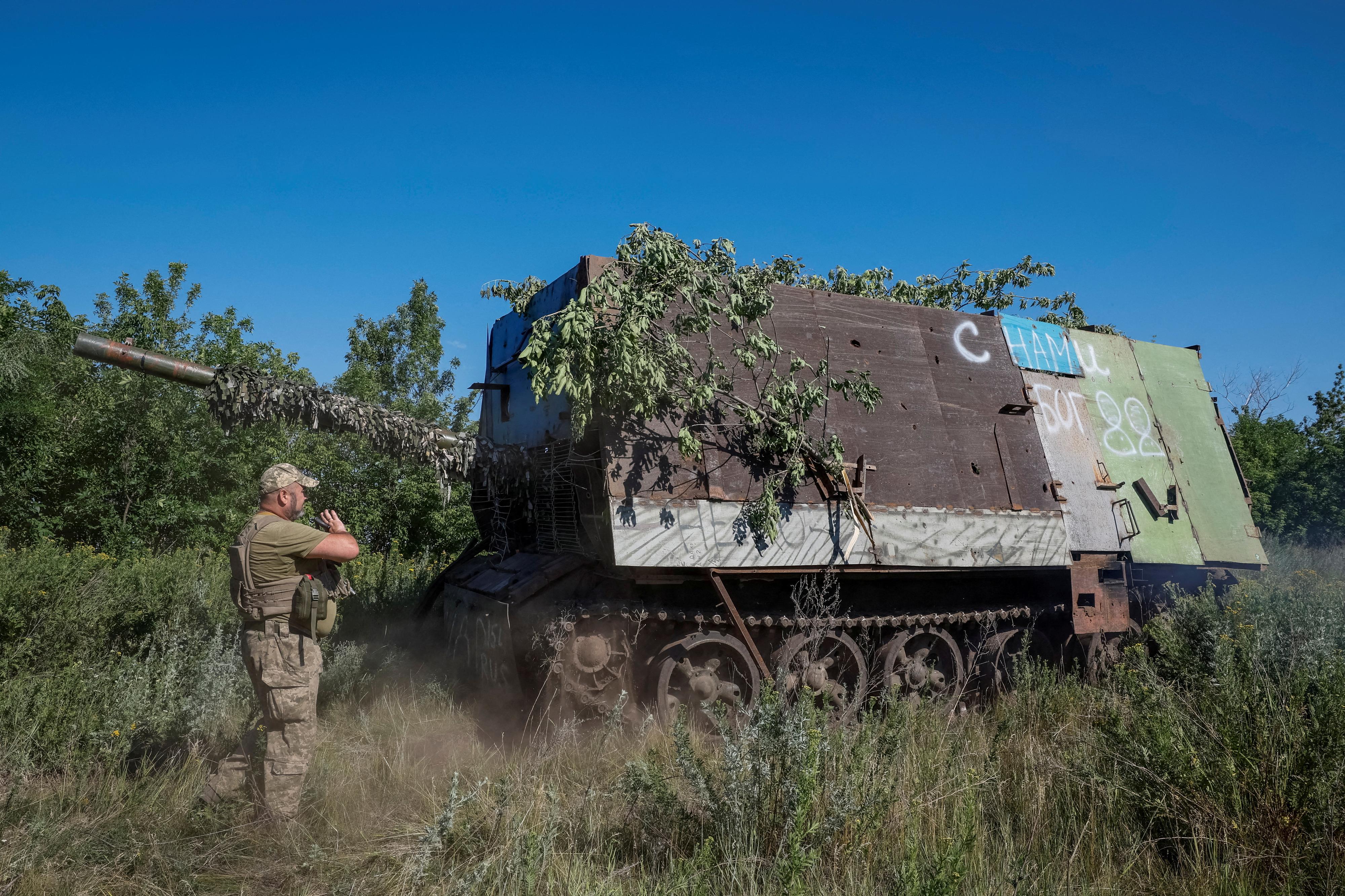 Un militaire ukrainien se tient à côté d'une "tortue", un char de combat T-62 doté d'une protection anti-drone qui a été récemment capturé par son unité dans la région de Donetsk, 19 juin 2024. [REUTERS - Alina Smutko]