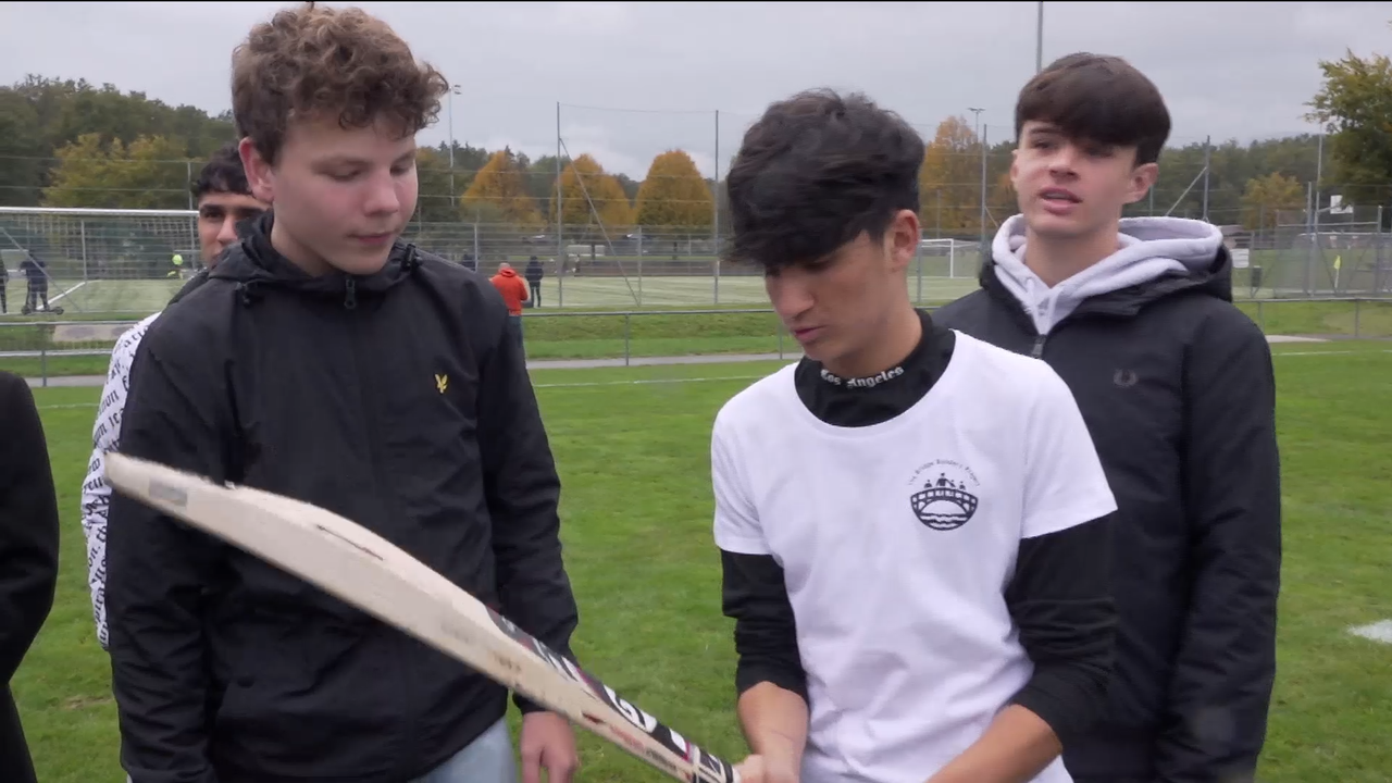 Bilal, réfugié afghan de 15 ans, initie ses camarades de jeu novices au cricket. [RTS]