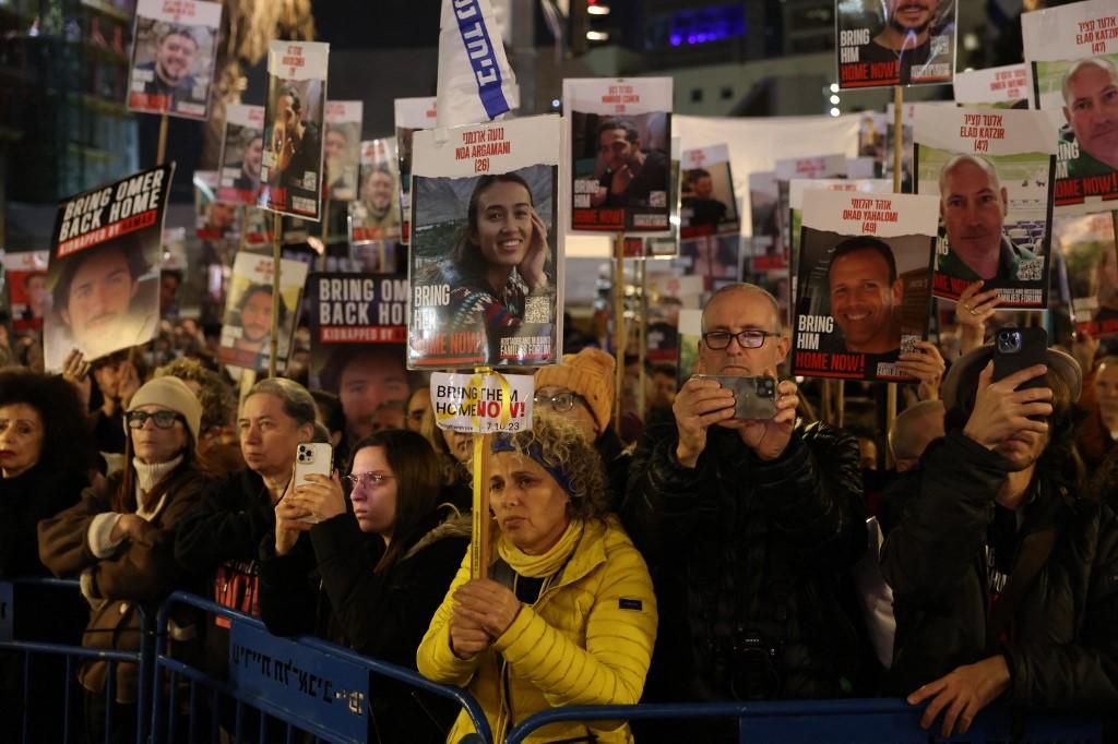 Des manifestants brandissent des pancartes avec les portraits d'otages qui seraient détenus dans la bande Gaza, lors d'un rassemblement appelant à leur libération à Tel-Aviv. [AFP - AHMAD GHARABLI]