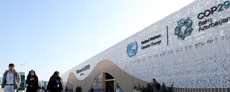 Des participants arrivent pour assister à la Conférence des Nations unies sur le changement climatique COP29 à Bakou, en Azerbaïdjan, le 10 novembre 2024. [KEYSTONE - IGOR KOVALENKO]