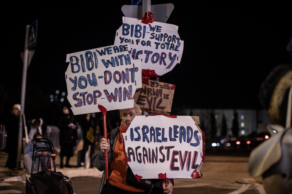 Une manifestante tient des pancartes en soutien au Premier ministre Benjamin Netanyahu et son gouvernement lors d'un rassemblement à Jérusalem devant le Parlement israélien contre un éventuel accord de cessez-le-feu à Gaza. [Anadolu via AFP - MUSTAFA ALKHAROUF]