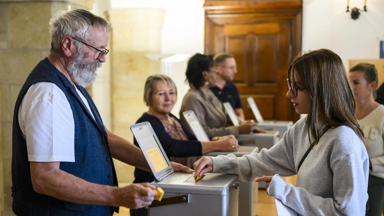 Une femme vote lors des élections fédérales du 22 octobre 2023. [Keystone - Jean-Christophe Bott]