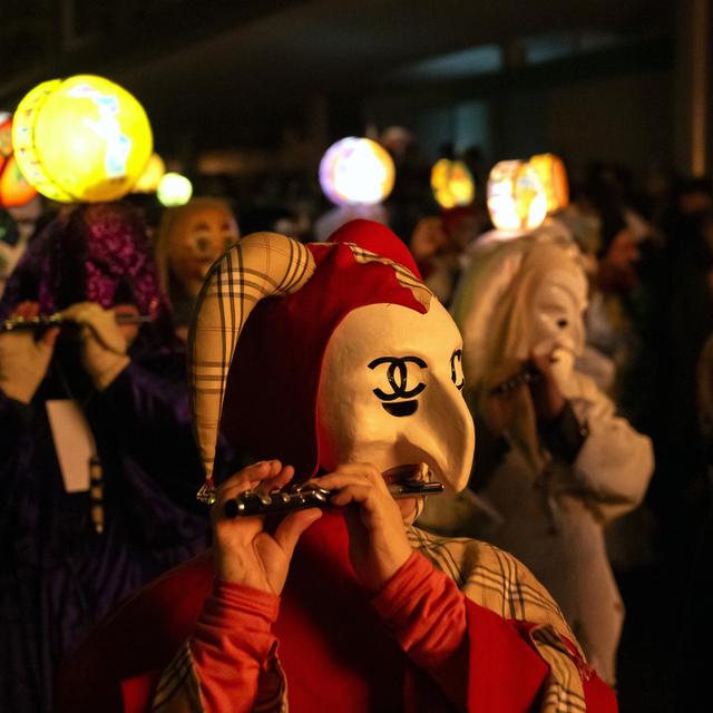 Des cliques de carnaval avec des lanternes défilent dans les rues lors du Morgestraich à Bâle, le lundi 19 février 2024. [Keystone - Georgios Kefalas]