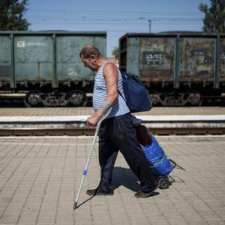 Un homme fuit la ville de Pokrovsk (Ukraine), le 19 août 2024. [AP Photo / KEYSTONE - Evgeniy Maloteka]