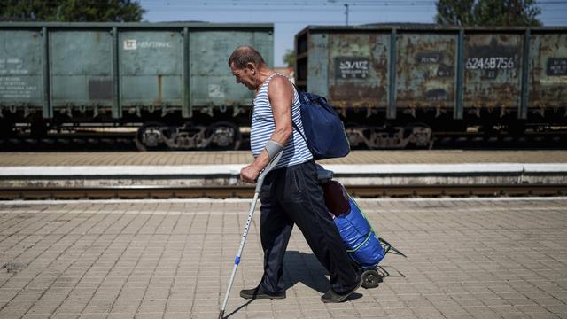 Un homme fuit la ville de Pokrovsk (Ukraine), le 19 août 2024. [AP Photo / KEYSTONE - Evgeniy Maloteka]