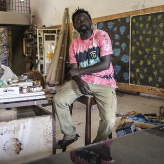 L'artiste sénégalais Omar Ba pose dans son atelier à Sangalkam en mai 2022. [AFP - John Wessels]