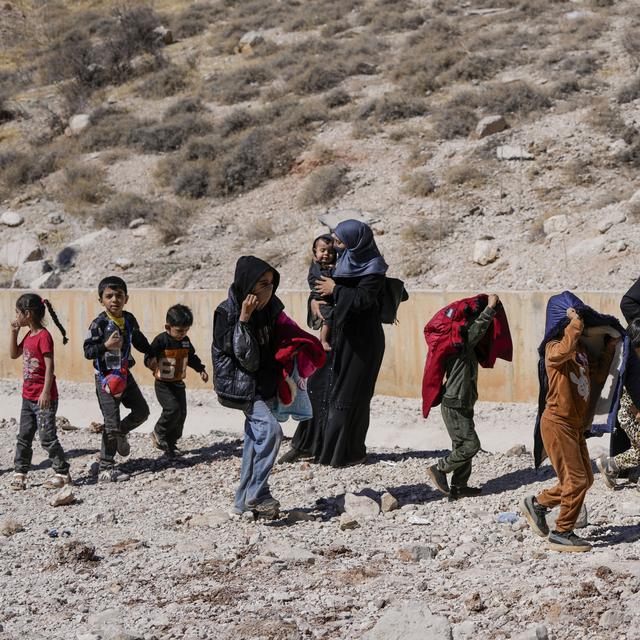 Plusieurs familles fuient le Liban à pieds vers la Syrie pour échapper à l'armée israélienne. [Keystone/AP Photo - Hassan Ammar]