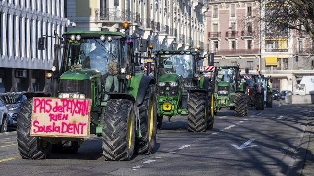 Des paysans révoltés défilent en cortège avec leurs tracteurs à Genève. [KEYSTONE - MARTIAL TREZZINI]