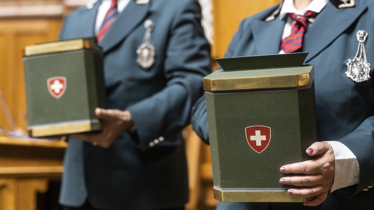 Des huissiers tiennent les urnes pendant les élections au bureau du Conseil national au premier jour de la session d'hiver des Chambres fédérales, le lundi 28 novembre 2022. [Keystone - Alessandro della Valle]