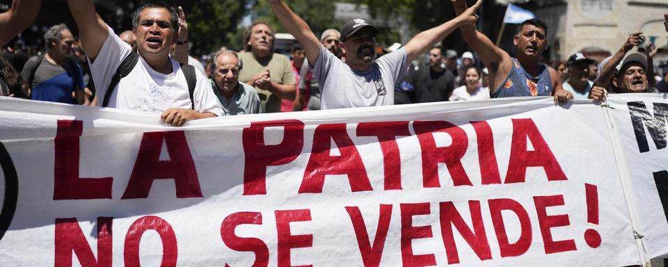 Des manifestants portent une banderole disant "Notre pays n'est pas à vendre!" pendant une grève nationale contre les réformes économiques et du travail proposées par le président argentin Javier Milei à Buenos Aires le 24 janvier 2024. [Keystone - AP Photo/Natacha Pisarenko]