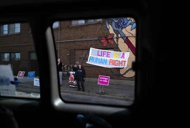 Près d'une vingtaine de militants anti-avortement ont manifesté dans la rue à l'extérieur de la clinique lors de la visite de Kamala Harris. [AFP - STEPHEN MATUREN]