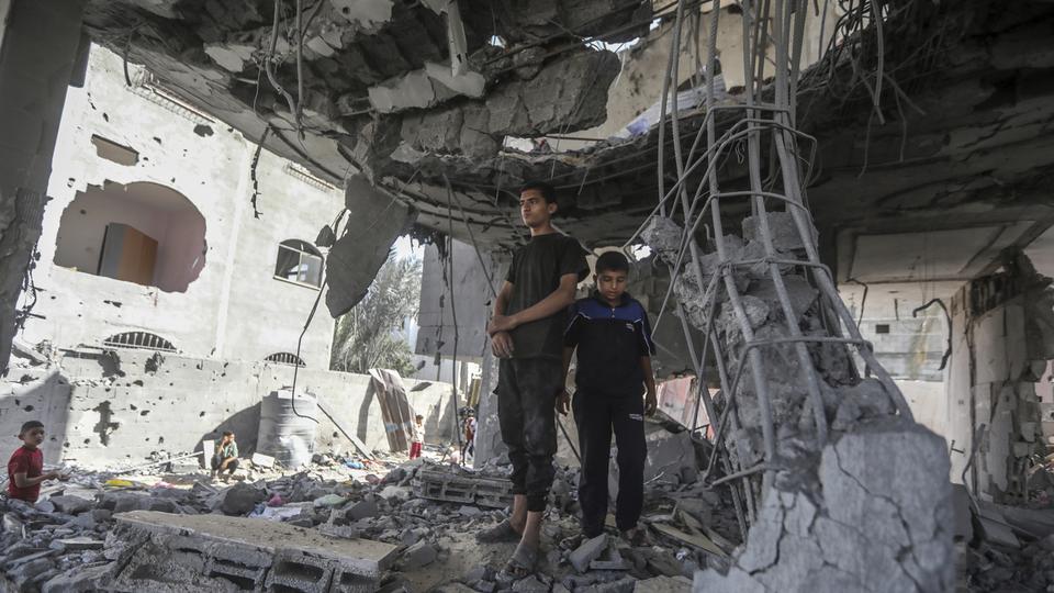 Deux personnes palestiniennes se tiennent dans les ruines de la maison de la famille Chahine, après une frappe israélienne qui a tué au moins deux adultes et cinq garçons et filles de moins de 16 ans à Rafah, dans le sud de la bande de Gaza, le vendredi 3 mai 2024. [Keystone - Ismael Abu Dayyah/AP Photo]