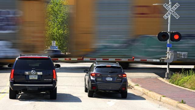 Des voitures attendent à un passage à niveau à Homestead, en Pennsylvanie, aux Etats-Unis. [AP Photo/Gene J. Puskar]