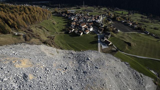 Vue de Brienz (GR) le 9 novembre 2024 et de la coulée qui a failli atteindre le village le 15 juin 2023. [KEYSTONE - GIAN EHRENZELLER]