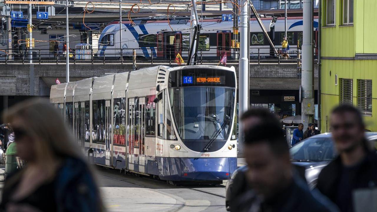 Des personnes passent devant un tram des Transports publics genevois (TPG). [Keystone - Martial Trezzini]