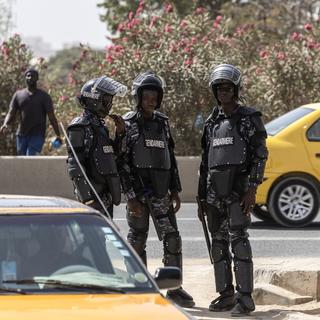 Des policiers montent la garde pour empêcher le rassemblement des candidats de l'opposition à la présidentielle et de leurs partisans à Dakar. [EPA/ Keystone - Jérôme Favre]