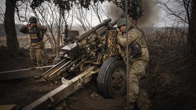 Des soldats ukrainiens tirent avec un obusier M101 en direction des positions russes sur la ligne de front, près d'Avdiivka, dans la région de Donetsk, en Ukraine, le vendredi 22 mars 2024. [KEYSTONE - EFREM LUKATSKY]