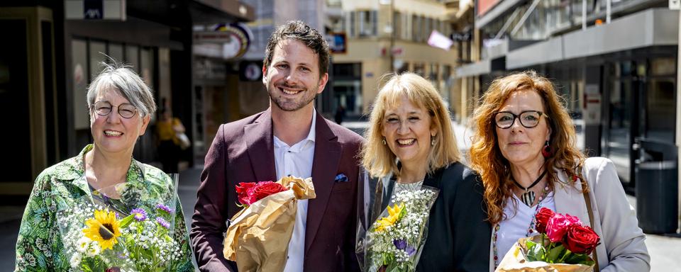 Johanna Lott Fischer (Les Verts), Jonathan Gretillat (PS), Nicole Baur (Les Verts) et Julie Courcier Delafontaine (PS) après leur victoire aux élections communales de Neuchâtel. [Keystone - Jean-Christophe Bott]