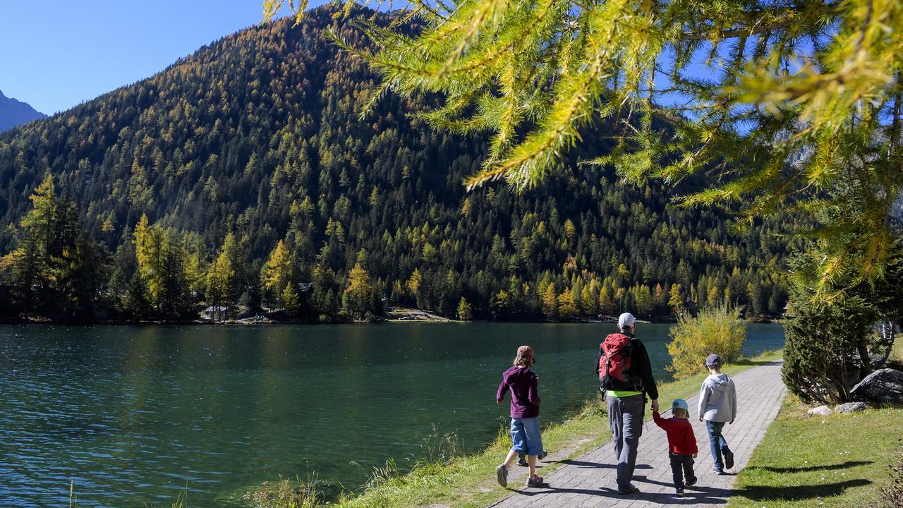 Une famille marche à Champex-Lac en Valais. [Keystone - Jean-Christophe Bott]