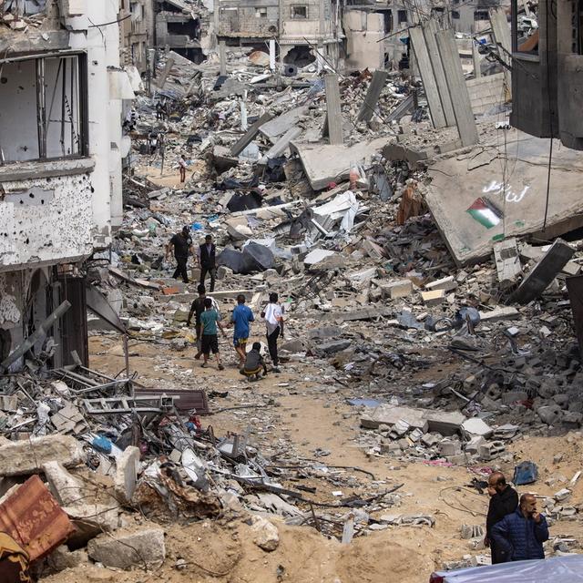 Des Palestiniens dans les ruines de Rafah bombardée. [Keystone/EPA - Haitham Imad]