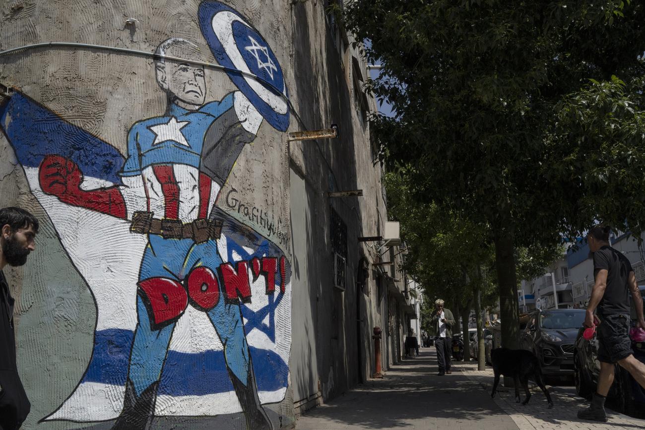 Un graffiti présentant le président américain Joe Biden tenant un bouclier pour protéger Israël, dans les rues de Tel-Aviv. [KEYSTONE - LEO CORREA]