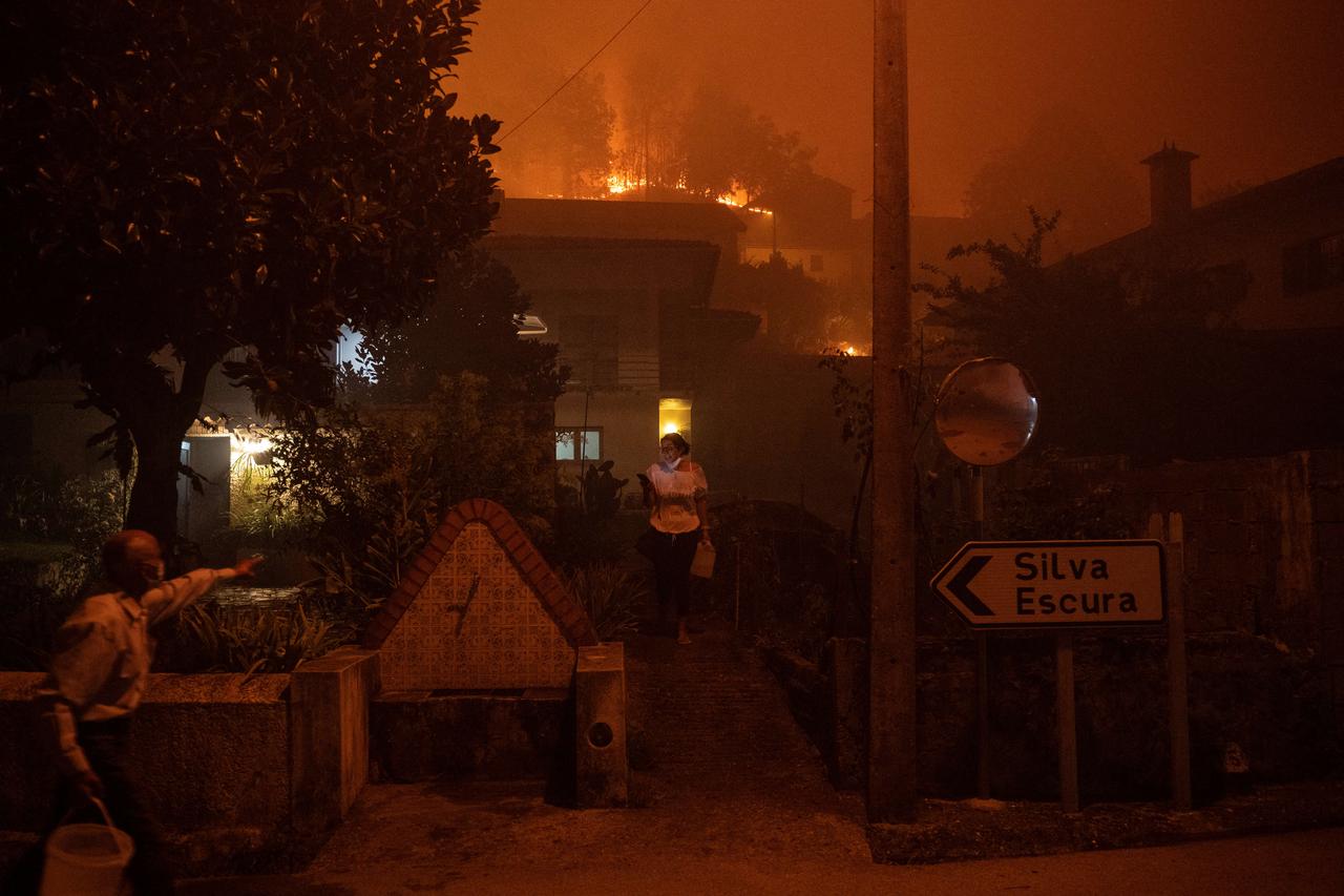 Une femme appelle à l'aide alors qu'un incendie de forêt s'approche de sa maison à Ribeira de Fraguas, le 16 septembre 2024. [AFP - PATRICIA DE MELO MOREIRA]