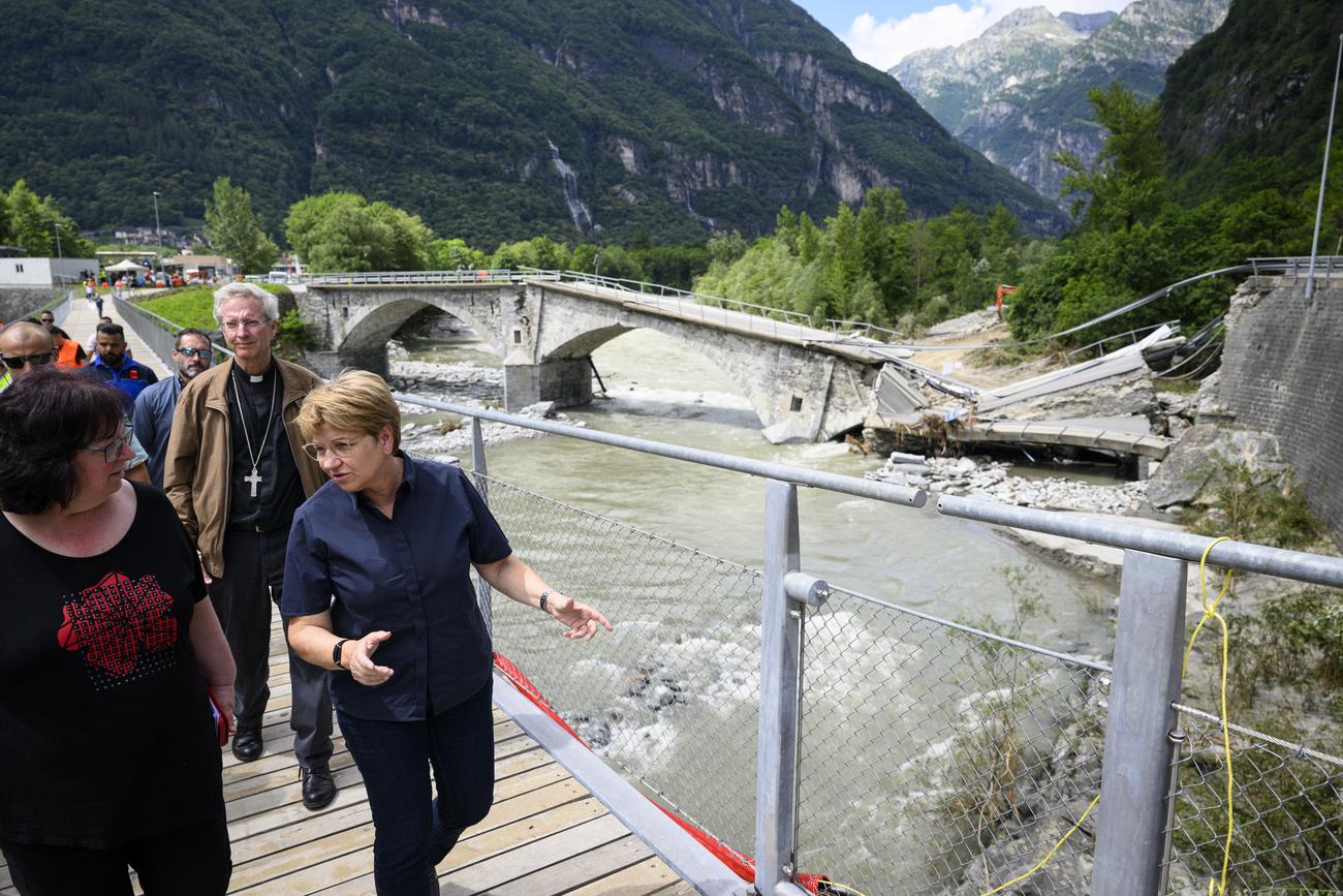 La présidente de la Confédération Viola Amherd, à droite, et la maire de Cevio Wanda Dado, à gauche visitent le pont effondré de Visletto entre Visletto et Cevio, dans le Val Maggia, le 1er juillet 2024. [KEYSTONE - JEAN-CHRISTOPHE BOTT]