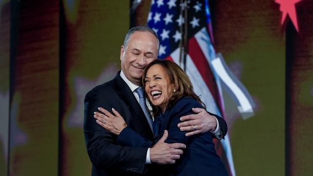 Tim Walz et Kamala Harris enlacés lors de la convention démocrate. [KEYSTONE - WILL OLIVER]