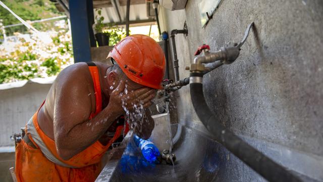 Ein Bauarbeiter einer Strassenbaustelle kuehlt sich bei einem Wasserhahn ab, am Donnerstag, 27. Juni 2019, in Lugano. Heute wurden im Tessin bis 38 Grad Celsius gemessen. (KEYSTONE/Ti-Press/Francesca Agosta) [Keystone - Francesca Agosta]